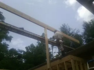 Carpenter setting a ridge beam over a new addition frame — Ice Dam Removal by Roofing Brothers in Brownsburg