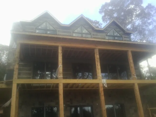 Dormers and porch framing on a large log home under construction — Roof Coating work by our crew in Brownsburg