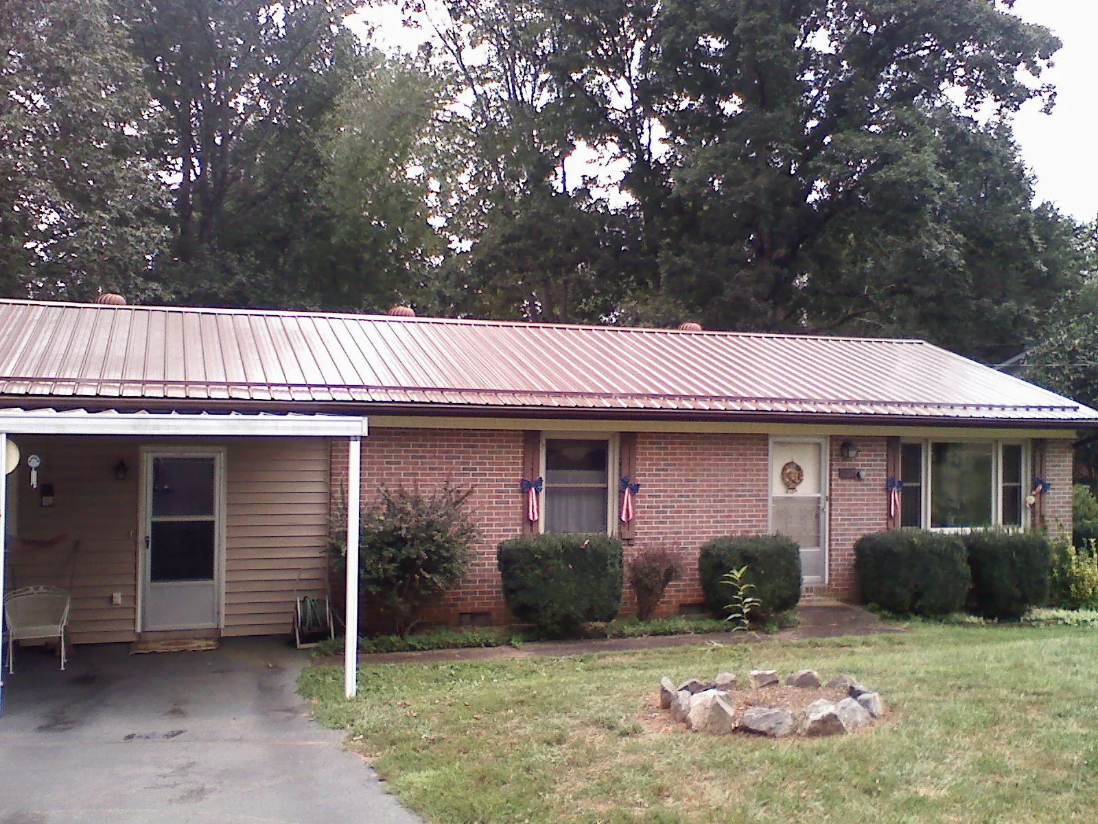 Bronze metal roof and carport on a brick ranch home — Roof Repair work by our crew in Brownsburg