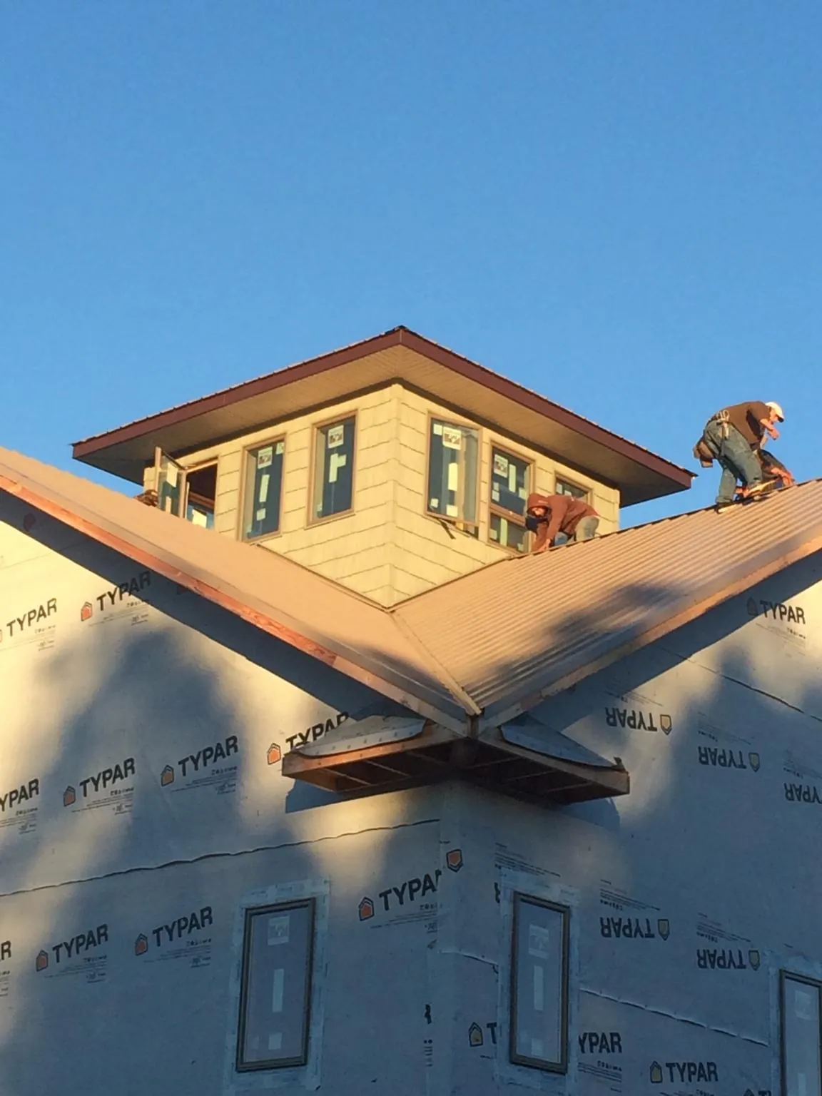 Roofers working around a rooftop cupola on a new metal roof at sunset — Roof Waterproofing in Brownsburg by Roofing Brothers